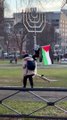 شاهد: متظاهر يعلّق علم فلسطين على شمعدان يهودي عملاق في الولايات المتحدة