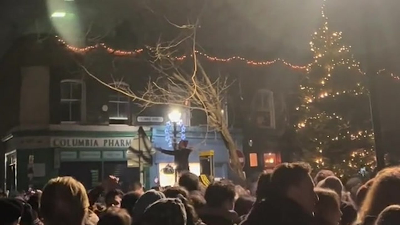 Crowds pack London’s Columbia Road for Christmas carols forcing