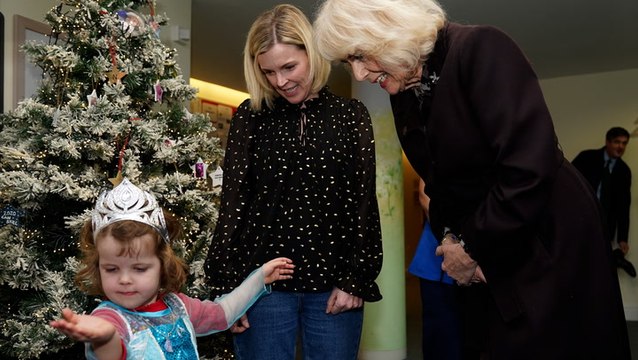 Queen Camilla admires little girl’s princess outfit as she turns on Christmas lights at children’s hospice