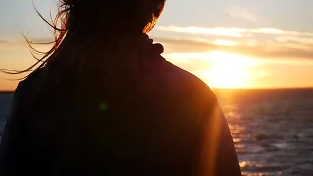Woman during a sunset on a rooftop.