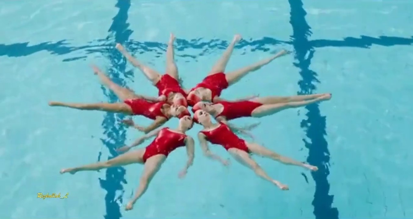 A group of girls performs an artistic show in the swimming pool with ...
