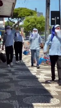 Papais Noéis da AtacadoCell percorrem a avenida Paraná entregando cestas de Natal para crianças