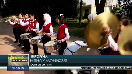 Ciudadanos sirios participan en un acto por el 65 aniversario de la Revolución Cubana