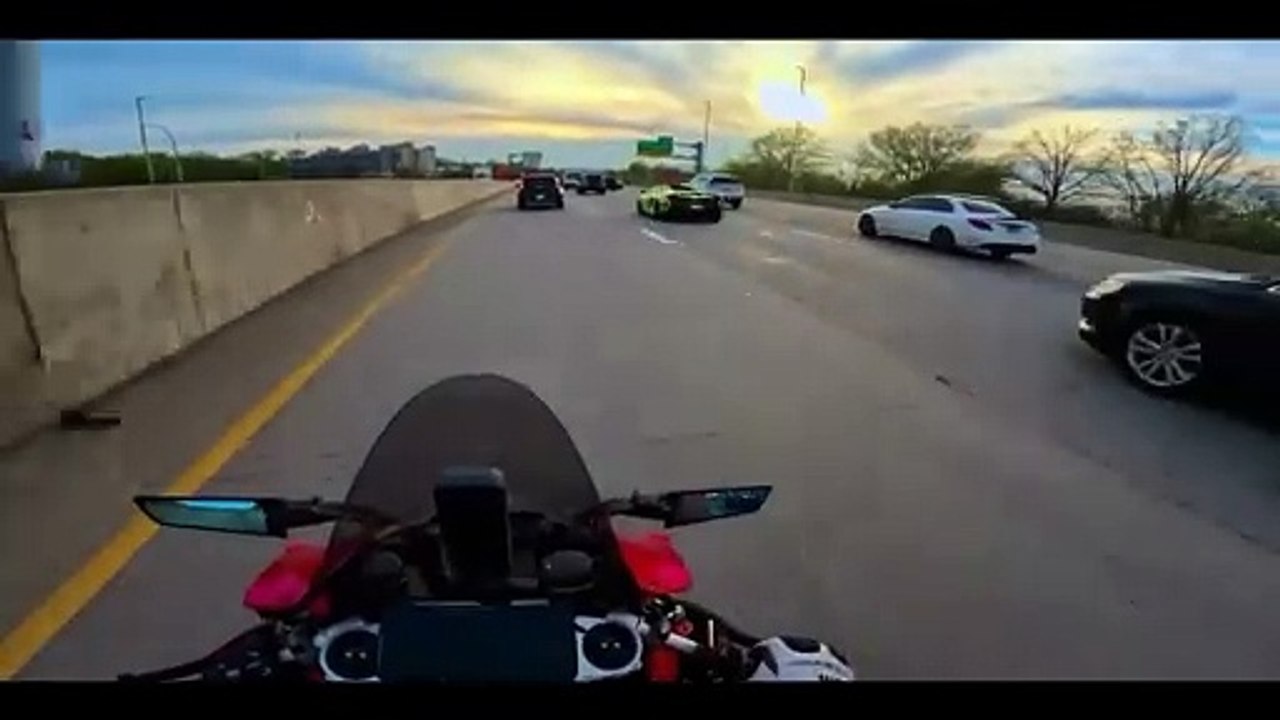 Ce motard admire une jolie voiture et évite le pire... bon reflexe