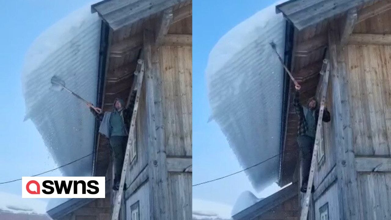 Mann bricht mit Schaufel dickes Stück Schnee von der Dachkante ab