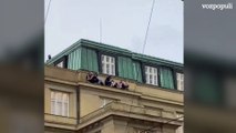 Estudiantes saltan de un edificio rodeado por la policía durante el tiroteo en el centro de Praga que ha dejado al menos 15 muertos y decenas de heridos.