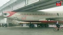 A scrapped aeroplane being transported by a truck got stuck