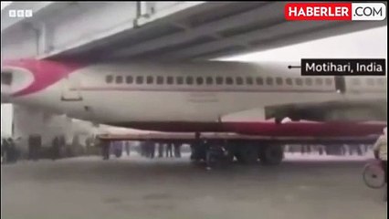 Hindistan'da hurdaya çıkan yolcu uçağının gövdesini taşıyan kamyon köprünün altına sıkıştı