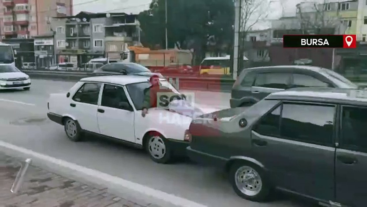 Bursa'da otomobilin kaputuna yatan kişinin ayaklarıyla öndeki aracı ittiği anlar