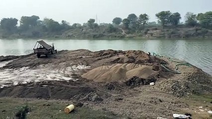 Mining mafia digging on the banks of the river in the dark of night