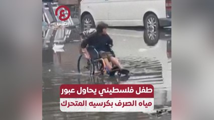 طفل فلسطيني يحاول عبور مياه الصرف بكرسيه المتحرك
