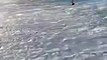 Un surfeur ravagé par une grosse vague en bord de plage