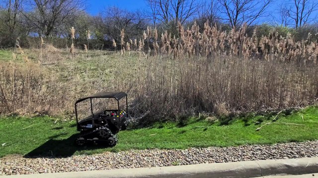 On flat and steep hill, cutting regular grass and tall brush