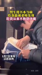 男生用課本吃泡麵。吃貨從不抱怨環境！Man use textbooks as bowls to eat instant noodles.