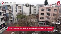 İş makinası yıkım için ağır hasarlı binanın üzerine çıkarıldı