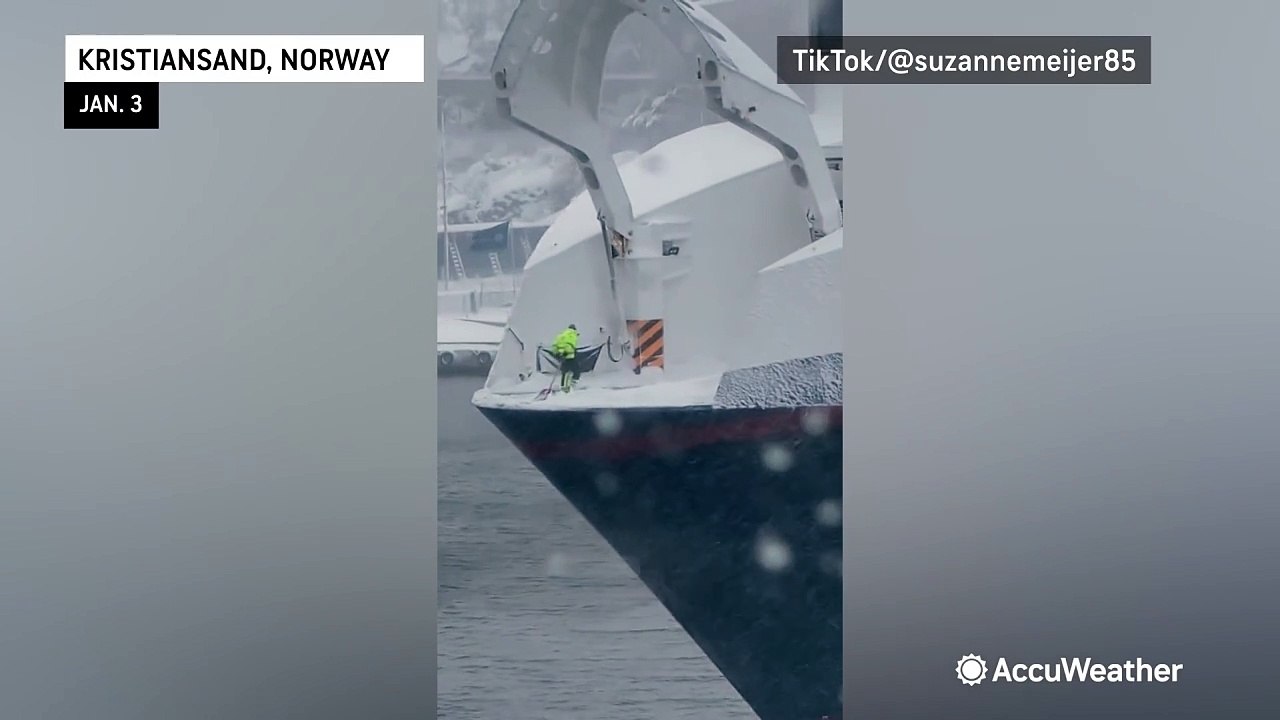 Brave man shovels snow off edge of boat in Norway