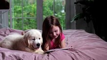 girl and her puppy watching videos