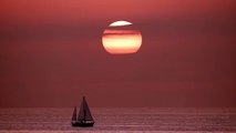 View of the horizon in the sea while a sailboat sails