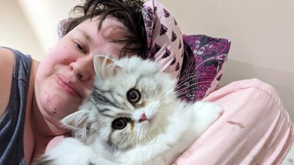 Molly Brooke in her home in Kingstanding, Birmingham, with her cat Maggie