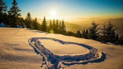 Heart shape in the snow mountains at sunset