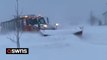 Snowplow pushes through thick pile of snow caused by severe storm in Buffalo, New York