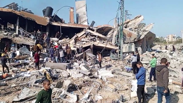 فلسطينيون يعاينون الدمار في مخيم الزوايدة وسط قطاع غزة