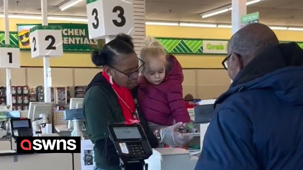 Supermarket worker helps mum by picking up crying toddler and scanning items with her