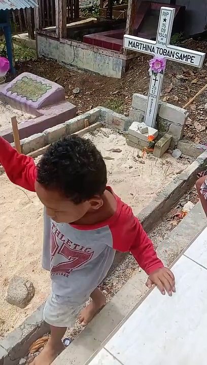 Cucu memberikan bunga di pusara neneknya