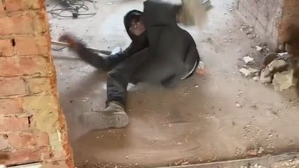 Apprentice boy using sledgehammer for the first time falls from its weight