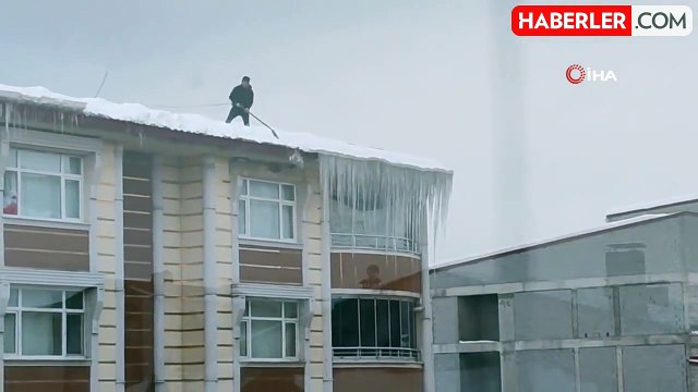İpin ucundaki hayat: Beline bağladığı iple tehlikeye aldırış etmeden çatıda biriken kar yığınını temizledi