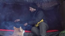 In the cold snow-covered mountain forest, I found a cave in front of me and used firewood to warm myself.