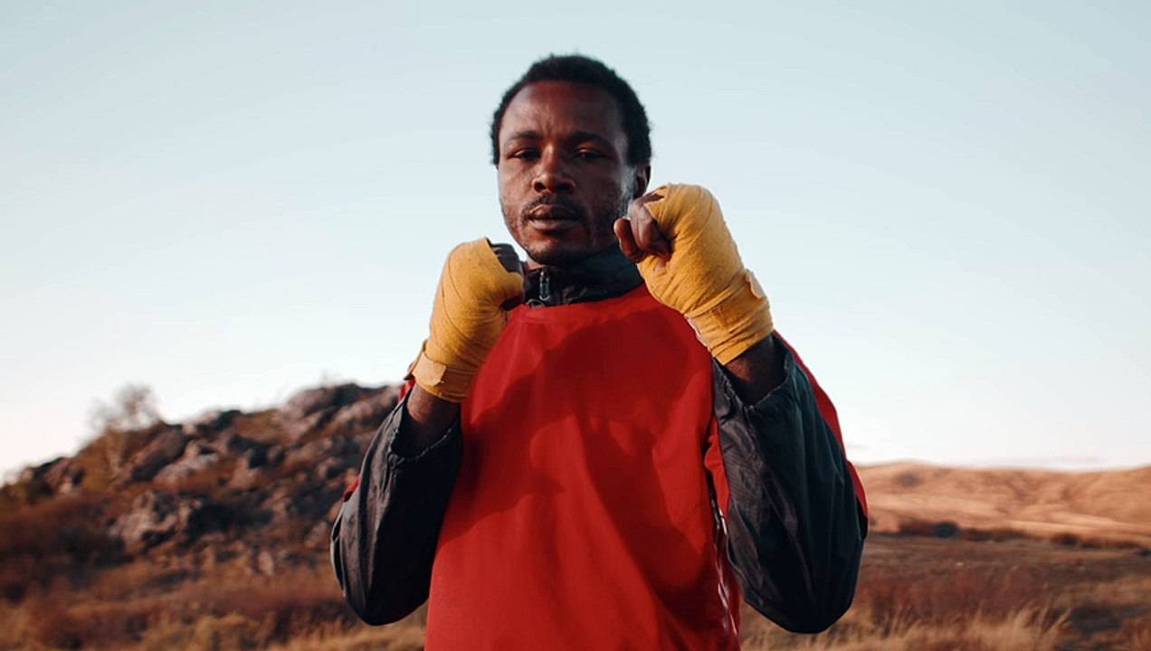 black-man-sports-uniform-stands-outdoors