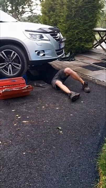 Woman Soaks Man Working Under Car