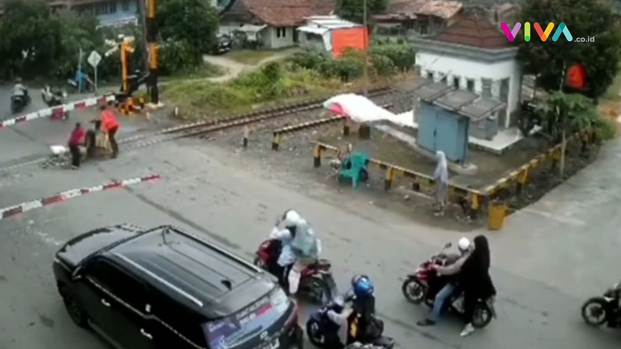 Petugas Selamatkan Pemotor Terobos Palang Pintu...