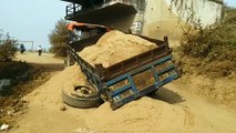 Tractor trolley filled with sand overturned in the bypass road connecting Nyas Colony to the highway.