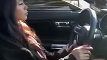 A beautiful girl driving a Ford Mustang