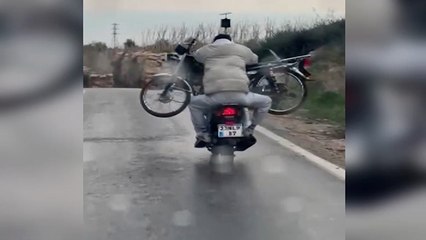 Motosikletle yolculuk sırasında başka bir motoru kucağında taşıdıla