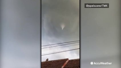 Debris flies under a tornado in Indonesia