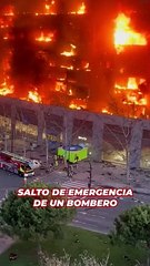 El salto de emergencia de un bombero a un colchón de rescate