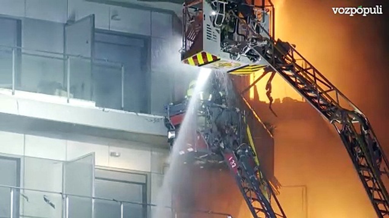 Los bomberos rescatan con dos grúas a dos personas del interior del edificio en llamas en Valencia