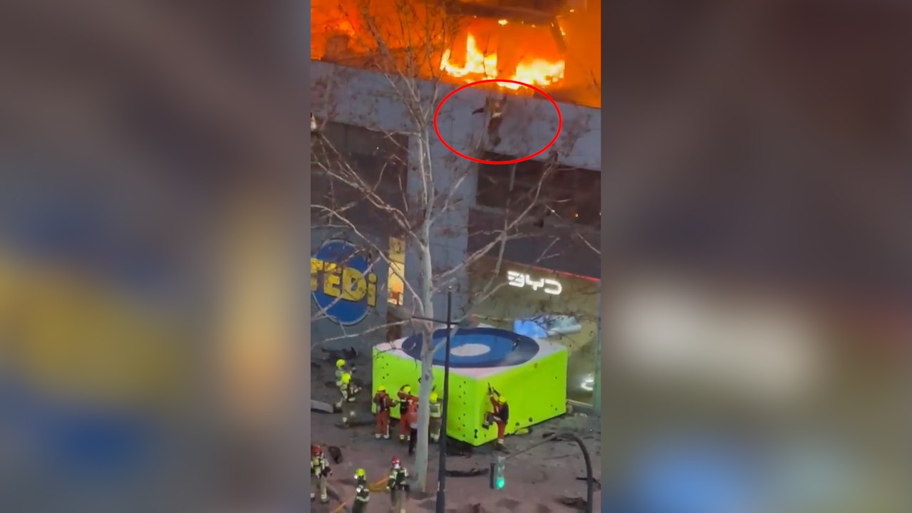 Un bombero escapa del incendio del edificio saltando sobre una camilla