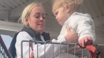Mother has a hard time putting her toddler in the shopping cart chair *Hilarious*