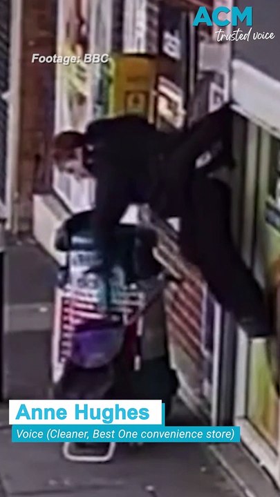 Woman lifted into the air after being caught on shop shutters