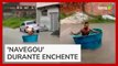 Homem é flagrado usando caixa d'água como barco em rua alagada na Bahia