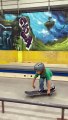 Boy on skateboard attempts 50-50 grind on rail at skatepark and lands on his arm