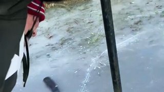 Boy with hockey stick gets his tongue stuck on pole on icy surface