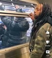 Guy stands beside subway window and a man snatches his toboggan off his head