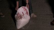 شاب يحمل كيس طحين مخضب بالدماء إلى مستشفى الشفاء