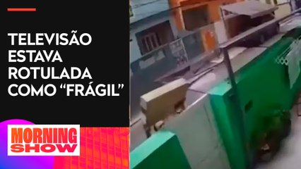 Entregador lança TV por cima de portão de casa