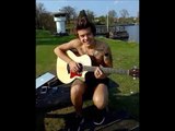 Harry Stykes tocando guitarra sin camisa